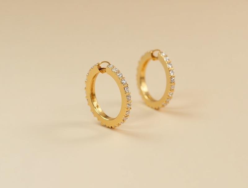 Pair of modern gold hoop earrings designed with subtle diamond accents along the edge